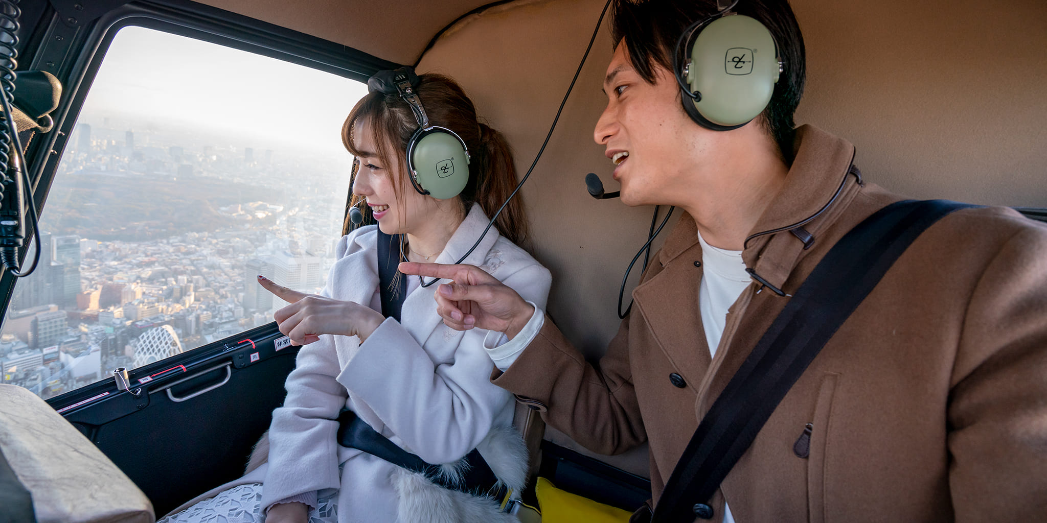 ヘリコプターで東京上空の遊覧をしているカップル