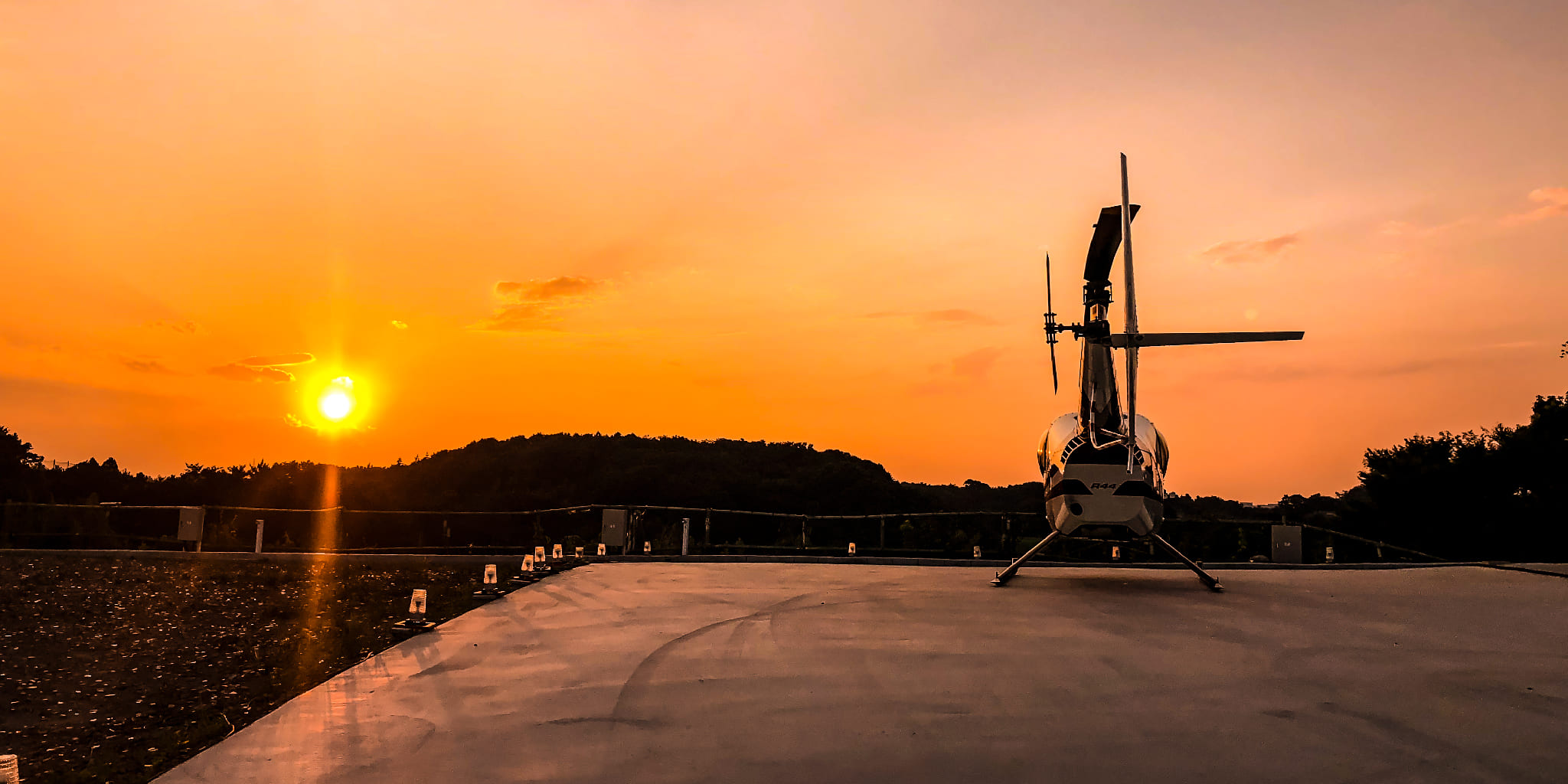 横浜西ヘリポートから見る夕焼けに照らされるヘリコプター